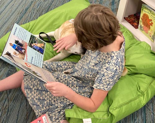 child reading book to dog