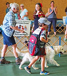 Adult volunteer, 4-H'er and dog in costume parade
