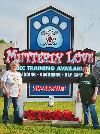 Two women standing in front of Mutterly Love sign